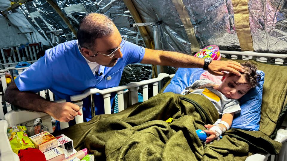 Dr. Abdallah Al-Naqbi checks on toddler Amir and his wounds. - Scott McWhinnie/CNN