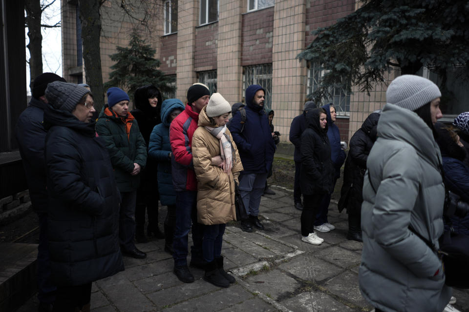 People attend a gathering to mark the first anniversary of the death of eight men killed by Russian forces in Bucha, Ukraine, Saturday, March 4, 2023. The eight had set up a roadblock on a road in the town in an attempt to prevent Russian troops from advancing, as they swept towards the Ukrainian capital at the start of their invasion. (AP Photo/Thibault Camus)