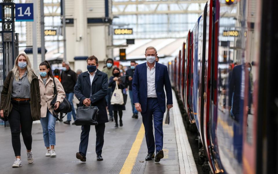 Bleary-eyed commuters donned their masks at London Waterloo rail station this morning after England's Euro defeat - Hollie Adams/Bloomberg