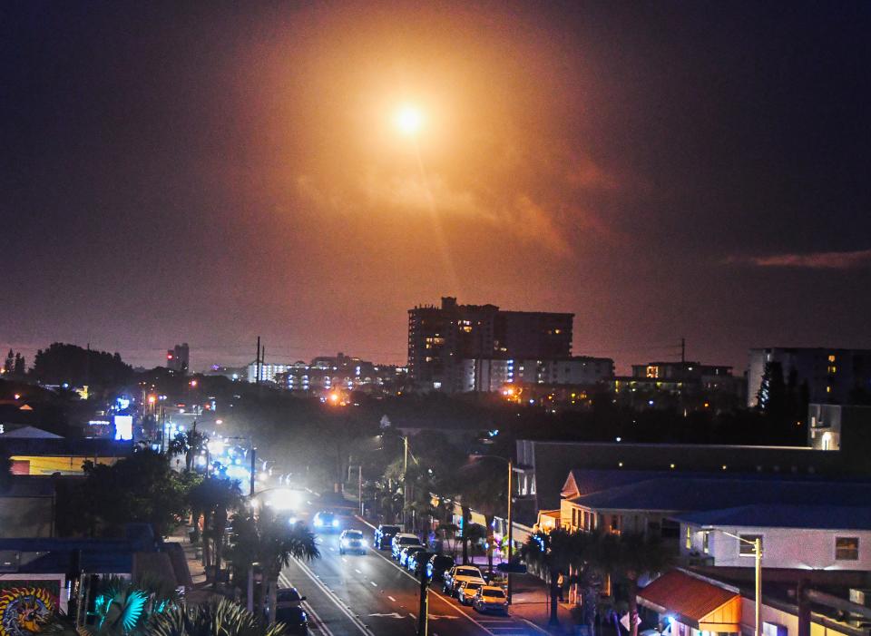 A SpaceX Falcon 9 rocket resembles the sun after launch Monday night from Cape Canaveral Space Force Station, viewed over the skyline of Cocoa Beach.