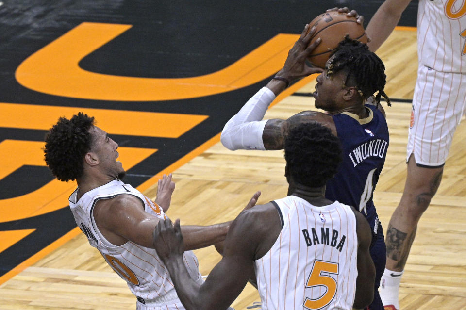 New Orleans Pelicans forward Wes Iwundu (4) is fouled by Orlando Magic guard Devin Cannady, left, while driving to the basket during the second half of an NBA basketball game Thursday, April 22, 2021, in Orlando, Fla. (AP Photo/Phelan M. Ebenhack)