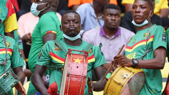 Suporter Kamerun bermain drum menjelang upacara pembukaan turnamen sepak bola Piala Afrika (CAN) 2021 di Stade d&#39;Olemb&#xe9; di Yaounde (9/1/2022). Piala Afrika 2021 seharusnya digelar Januari 2021 tapi kemudian diundur karena pandemi. (AFP/Kenzo Tribouillard)
