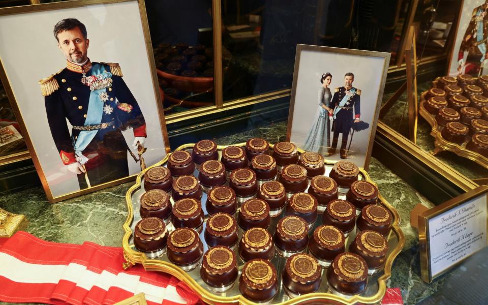 Portraits of Crown Prince Frederik and Crown Princess Mary next to cakes in a confectionary shop window in Copenhagen