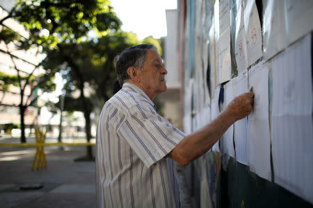 A man checks electoral lists at a polling station during the municipal legislators election in Caracas, Venezuela December 9, 2018. REUTERS/Marco Bello