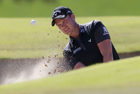 Danny Willett of England hits the ball out of the bunker on the sixth hole during the Dubai Desert Classic golf championship February 6, 2016. REUTERS/Ahmed Jadallah