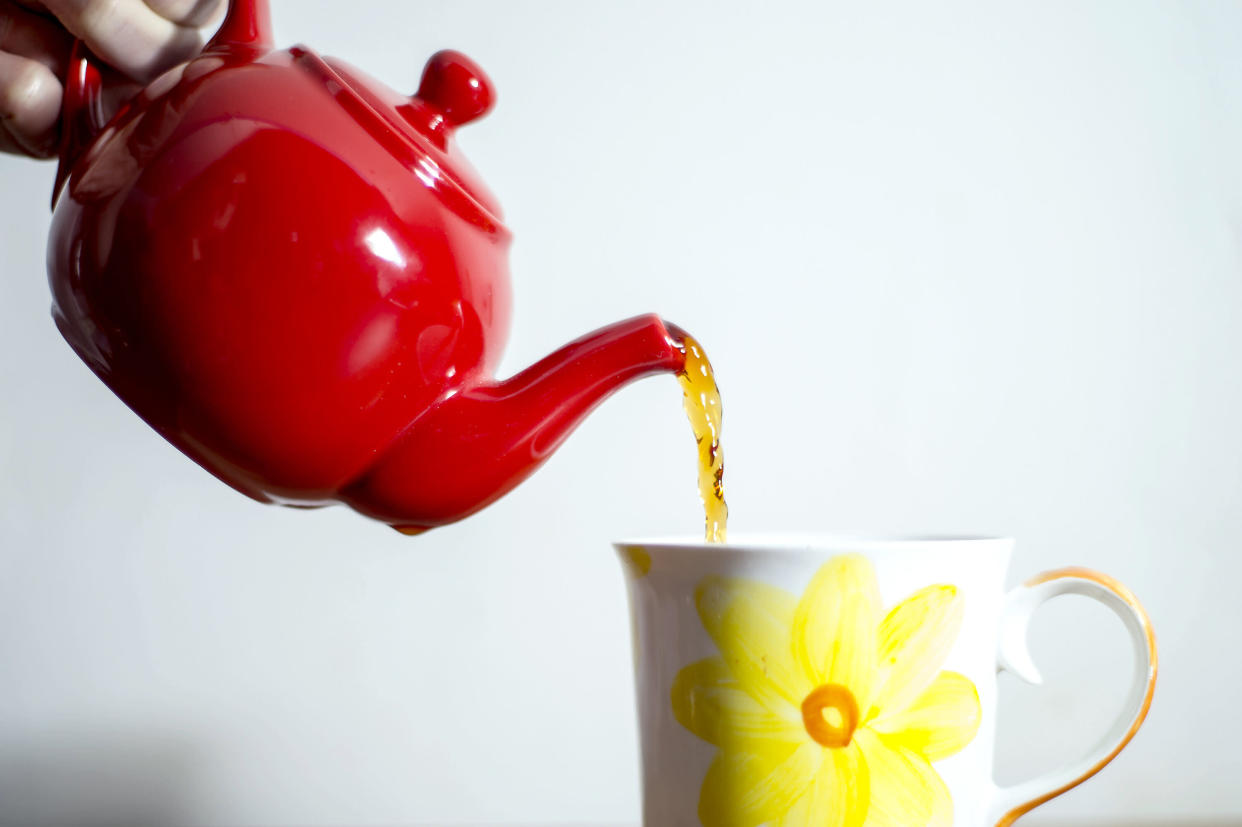 English breakfast tea is poured from a teapot.