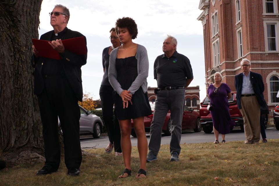 Father Jim Sauer, left, stands with 17-year-old Sophie Kloppenburg at a Mt. Vernon memorial ceremony Sunday, Oct. 23, 2022, dedicated to Indiana's deadliest lynching, which occurred in Posey County 144 years ago.