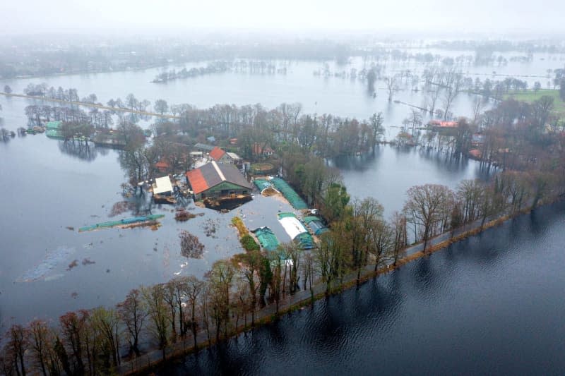 An aerial view taken by a drone shows a flooded farm. According to the forecasts of the German Weather Service (DWD), heavy rain is expected to continue, so the situation remains tense. Sina Schuldt/dpa