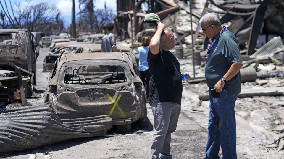Governor of Hawaii Josh Green, left, and Maui County Mayor Richard Bissen, Jr., speak during a tour of wildfire damage on Saturday, Aug. 12, 2023, in Lahaina, Hawaii. (AP Photo/Rick Bowmer)