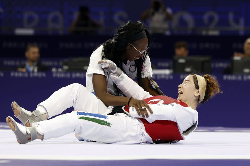 Zakia Khudadadi of the Refugee Paralympic Team, bottom, celebrates her bronze medal in para taekwondo during the Paralympic Games in Paris, Thursday, Aug. 29, 2024.