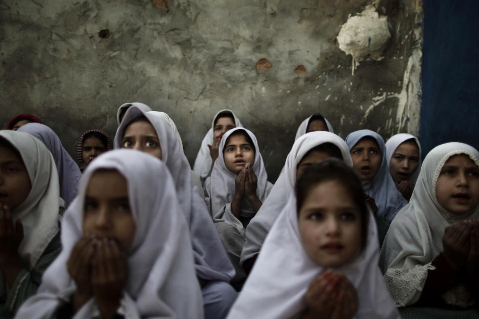 In this Thursday, Jan. 3, 2013 photo, Pakistani schoolgirls, who were displaced with their families from Pakistan's tribal areas due to fighting between militants and the army, chant prayers during a class to pay tribute for five female teachers and two aid workers who were killed by gunmen, at a school, on the outskirts of Islamabad, Pakistan. Wonder Woman and Supergirl now have a Pakistani counterpart in the pantheon of female superheroes _ one who shows a lot less skin. Meet Burka Avenger: a mild-mannered teacher with secret martial arts skills who uses a flowing black burka to hide her identity as she fights local thugs seeking to shut down the girls' school where she works. Sadly, it's a battle Pakistanis are all too familiar with in the real world.(AP Photo/Muhammed Muheisen)