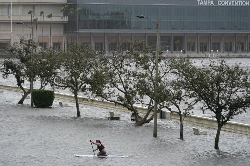 Zeke Pierce rides his paddle board down the middle of a flooded Bayshore Blvd in downtown in Tampa, Fla., Wednesday, Aug. 30, 2023. Hurricane Idalia steamed toward Florida’s Big Bend region Wednesday morning, threatening deadly storm surges and destructive winds in an area not accustomed to such pummeling. (AP Photo/Chris O'Meara)