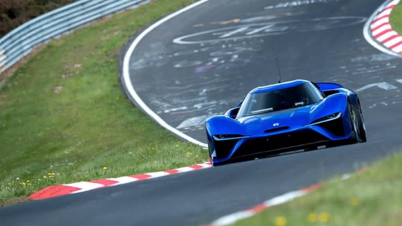 A blue NIO ES9, a low-slung electric sports car, is shown on a racetrack.