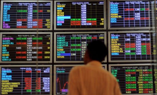 A man monitors shares trading on electronic screens in Kuala Lumpur, 2009. Asian markets mostly climbed, with hopes rising for a new round of stimulus from the US and European central banks, but profit-taking reversed earlier gains in Hong Kong