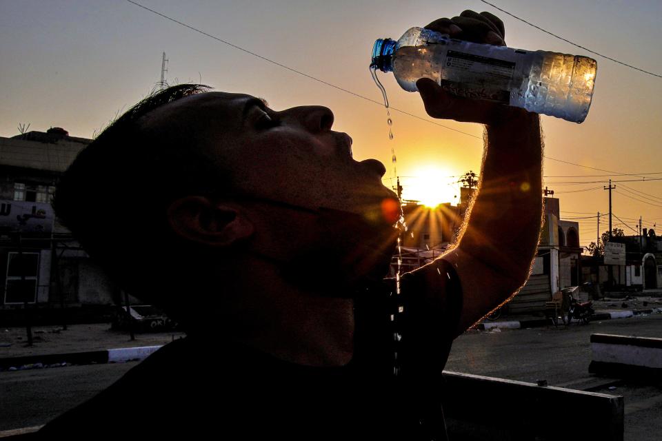 Laith Jabbar, a gas station worker drinks water in Basra, Iraq, Monday, July. 27, 2020. As temperatures soar to record levels this summer, Iraq's power supply falls short of demand again, providing a spark for renewed anti-government protests. Amid a nationwide virus lockdown, homes are without electricity for hours in the blistering heat. (AP Photo/Nabil al-Jurani)