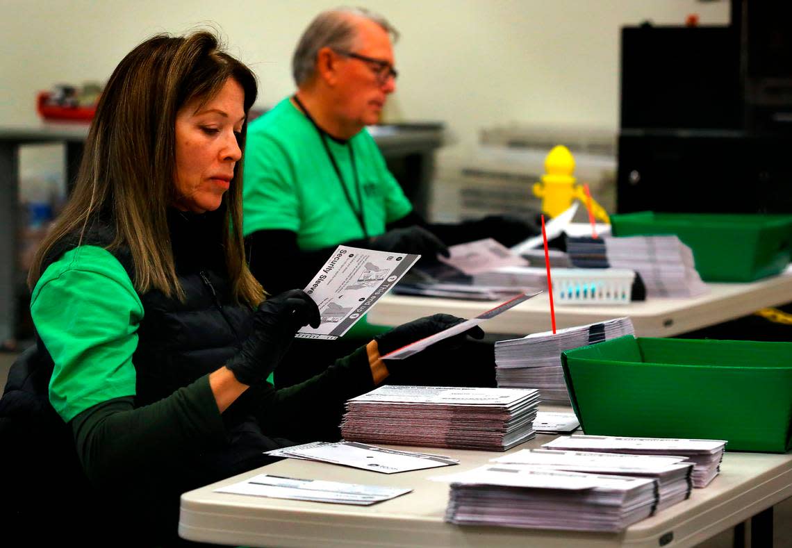 Elections workers open ballot envelopes in preparation for scanning and tabulating at the Benton County Voting Center in Richland in 2022.