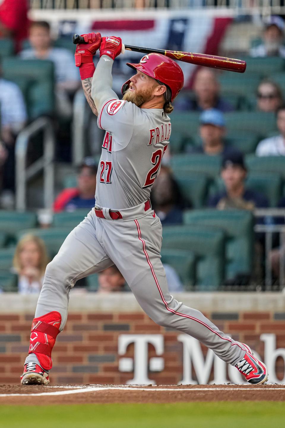 Apr 12, 2023; Cumberland, Georgia, USA; Cincinnati Reds right fielder Jake Fraley (27) hits a sacrifice fly ball against the Atlanta Braves during the first inning at Truist Park.