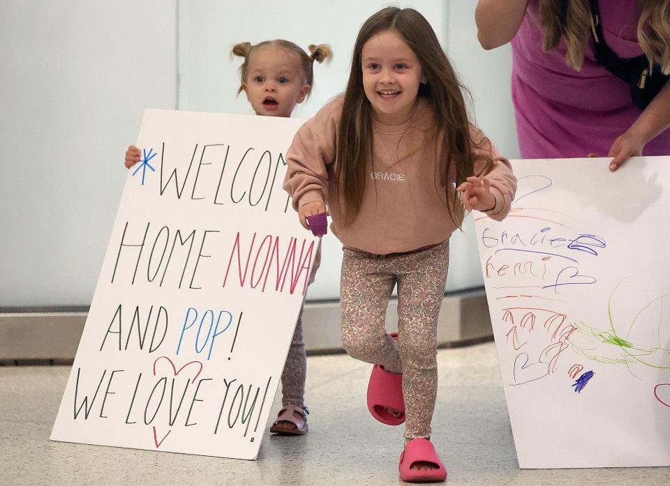 Remi Trowbridge holds a sign as Gracie Trowbridge runs to her grandparents as they arrive from Italy at the Salt Lake City International Airport in Salt Lake City on Tuesday, June 20, 2023. | Kristin Murphy, Deseret News