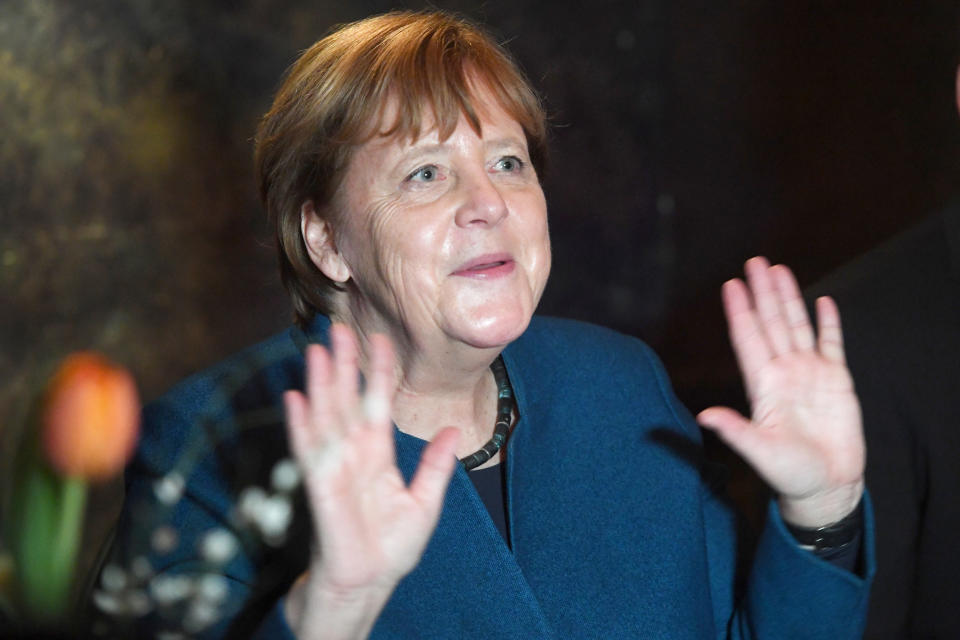 28 February 2020, Mecklenburg-Western Pomerania, Stralsund: Chancellor Angela Merkel (CDU) raises both hands up at the annual reception of her constituency to show that she does not want to shake hands with anyone because of a possible risk of infection by the corona virus. Merkel has represented the constituency of Stralsund-Greifswald-Rügen-Vorpommern with a direct mandate in the Bundestag since 1990. Photo: Stefan Sauer/dpa (Photo by Stefan Sauer/picture alliance via Getty Images)