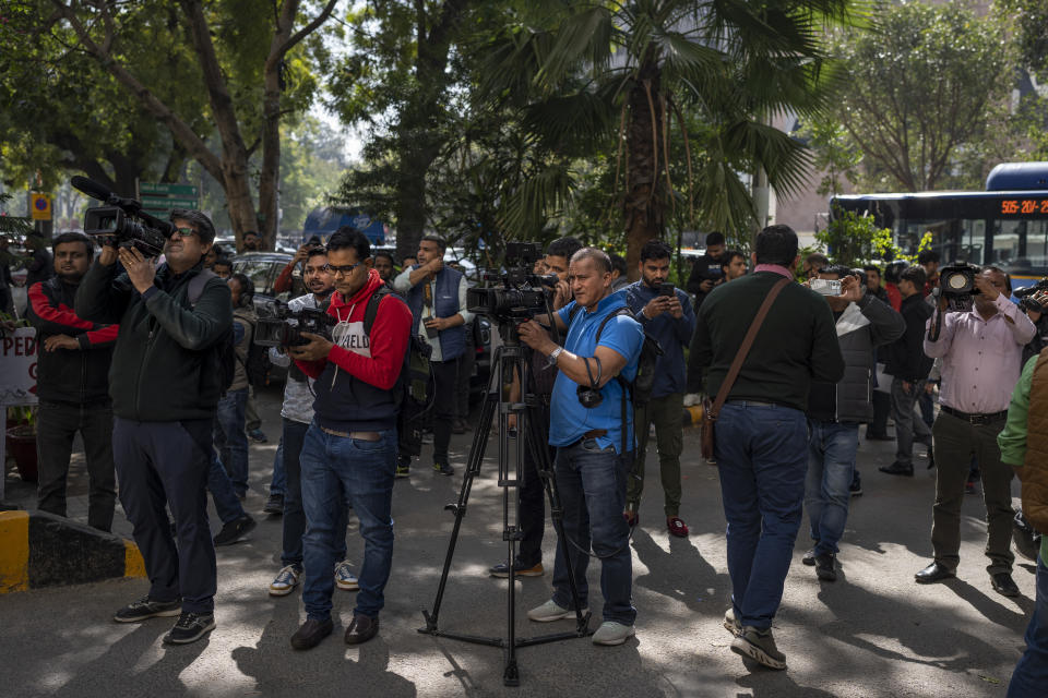 Media personnel report standing outside a building housing BBC office in New Delhi, India, Tuesday, Feb. 14, 2023. Officials from India's Income Tax department began conducting searches Tuesday at the BBC's offices in the capital, New Delhi, three of the broadcaster's staff members told the Associated Press. (AP Photo/Altaf Qadri)