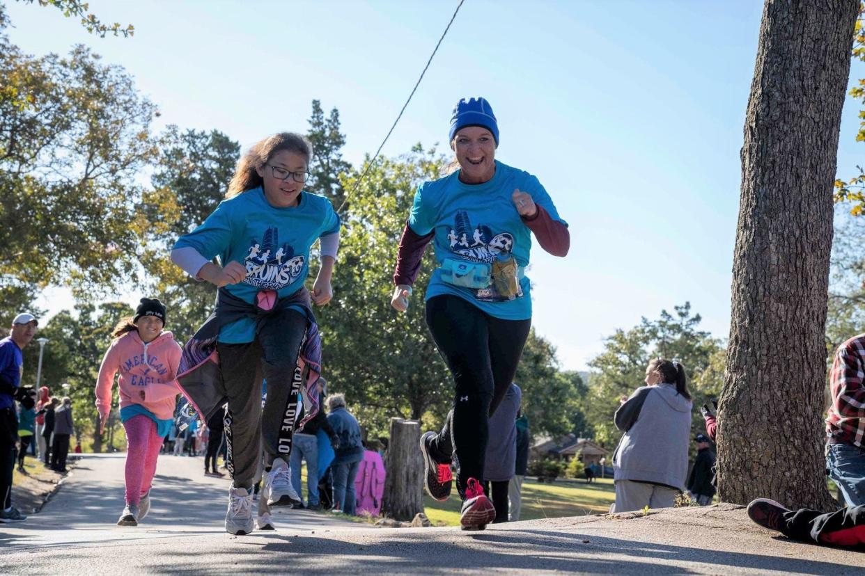 Bartlesville student Izora Frisbee and mentor Ashley Burson participate in a race as part of Bruins on the Run, a free afterschool running club for 5th-graders.