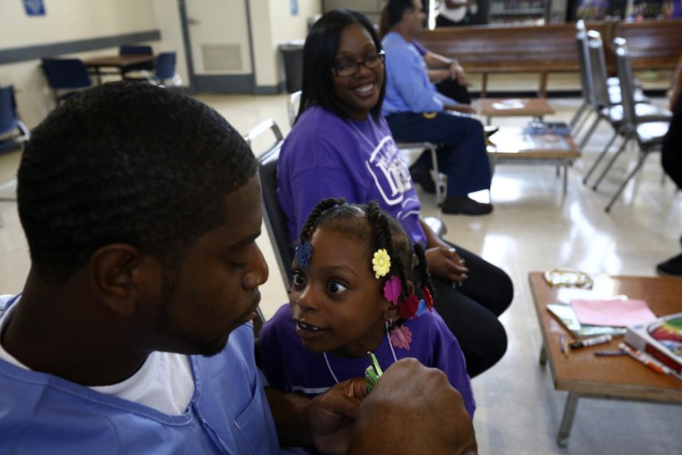 Tylan Gregory plays with his daughter during a "Get On the Bus" visiting day to Folsom State Prison