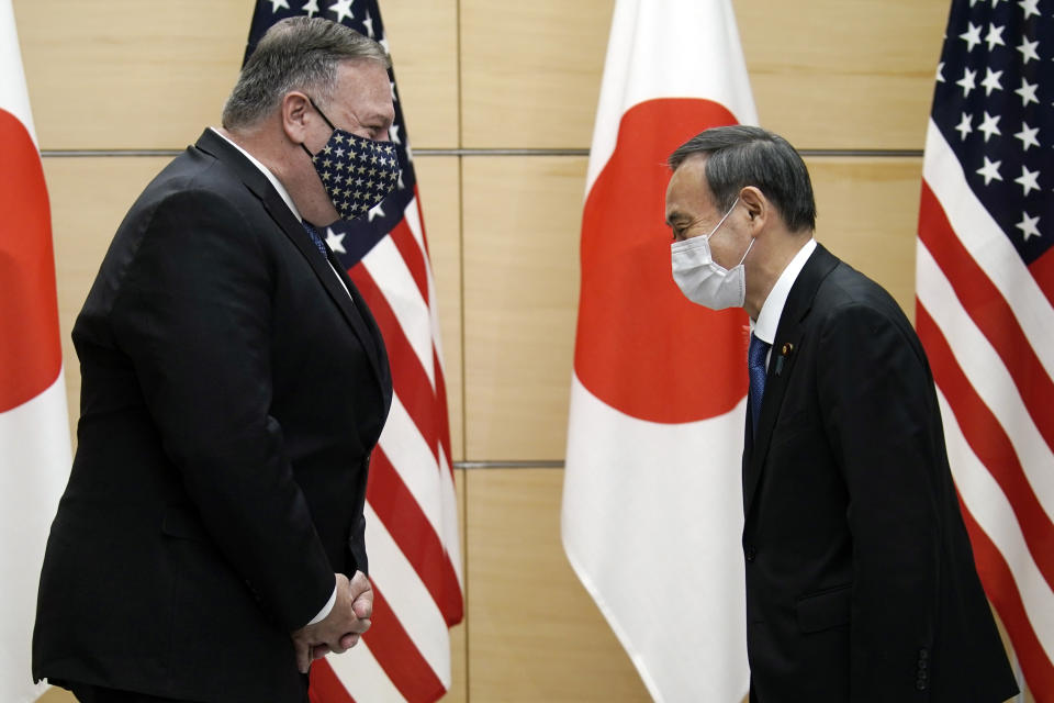 Japan's Prime Minister Yoshihide Suga, right, and U.S. Secretary of State Mike Pompeo, left, greet prior to their meeting at the prime minister's office Tuesday, Oct. 6, 2020, in Tokyo. Pompeo is in Japan to attend the four Indo-Pacific nations' foreign ministers meeting. (AP Photo/Eugene Hoshiko, Pool)
