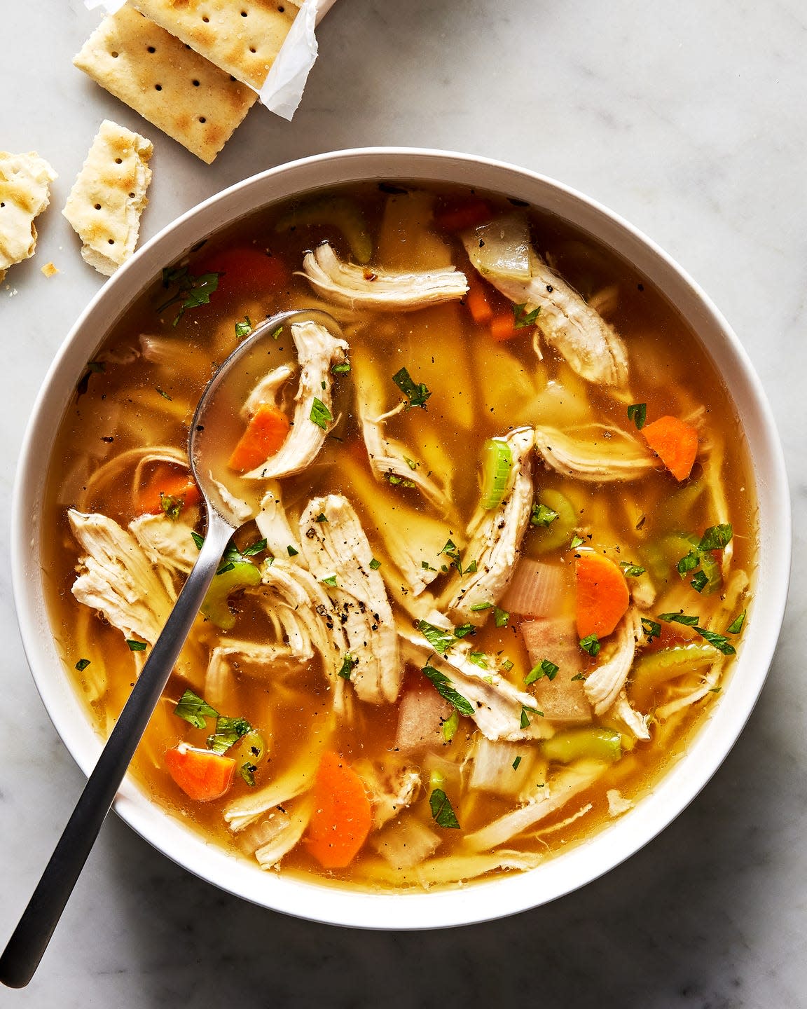 chicken soup in a bowl with saltines