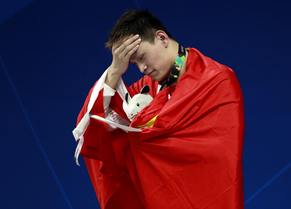 China's Sun Yang reacts on the podium after winning the gold medal in the men's 800m freestyle final during the swimming competition at the 18th Asian Games in Jakarta, Indonesia, Monday, Aug. 20, 2018. (AP Photo/Bernat Armangue)