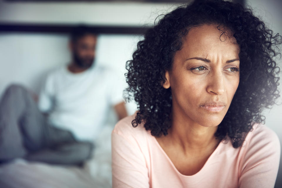 Woman looking upset with male partner in the background (Getty Images)