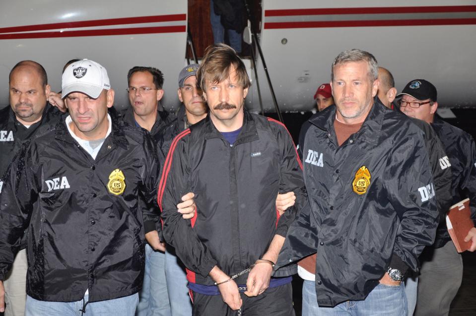 DEA agents escort Viktor Bout (center) off the plane after he was extradited to the United States.