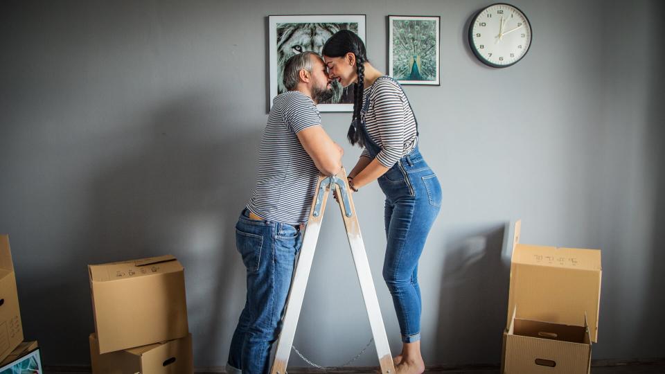 young family of new homebuyers putting up picture frames