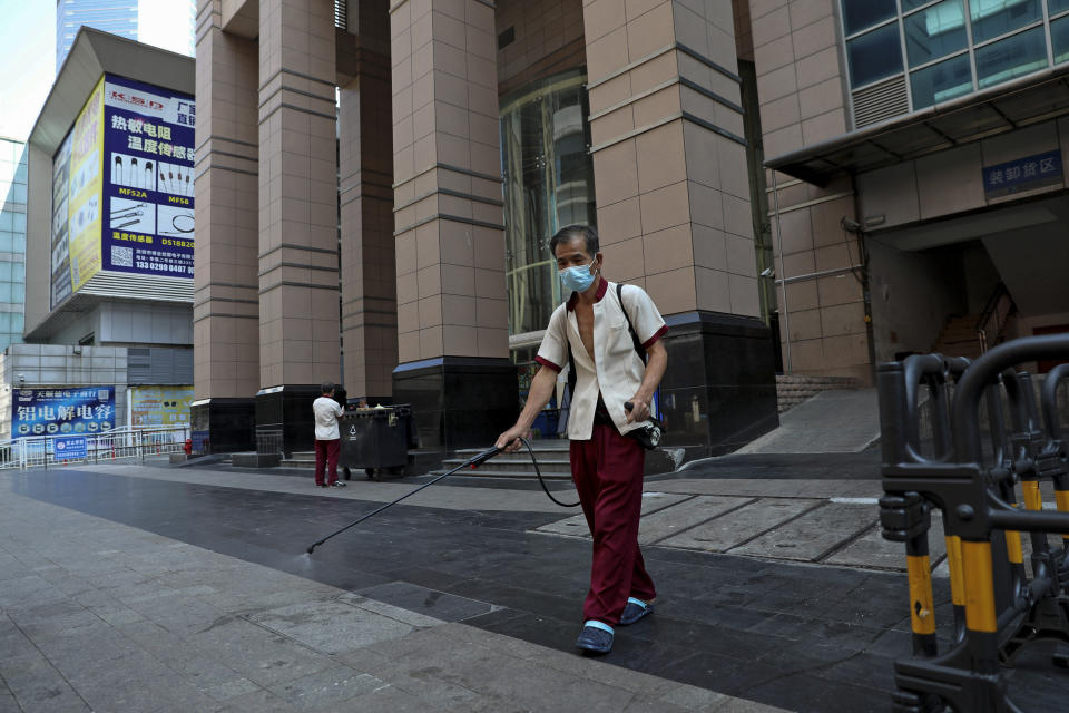 A worker sprays disinfectant around the shuttered Huaqiangbei Electronics Market following the coronavirus outbreak in Shenzhen in south China's Guangdong province on Sept. 3, 2022. China has locked down 65 million of its citizens under tough COVID-19 restrictions and is discouraging domestic travel during upcoming national holidays. (Chinatopix Via AP)