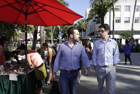 Felice Gorordo (L) and Raul Moas walk along a street in Miami Beach, Florida, December 19, 2014. REUTERS/Javier Galeano