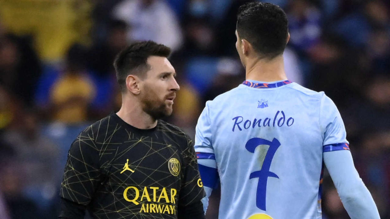 Paris Saint-Germain's Argentine forward Lionel Messi (L) walks past Riyadh All-Star's Portuguese forward Cristiano Ronaldo (R) during the Riyadh Season Cup football match between the Riyadh All-Stars and Paris Saint-Germain at the King Fahd Stadium in Riyadh on January 19, 2023. (Photo by FRANCK FIFE / AFP)