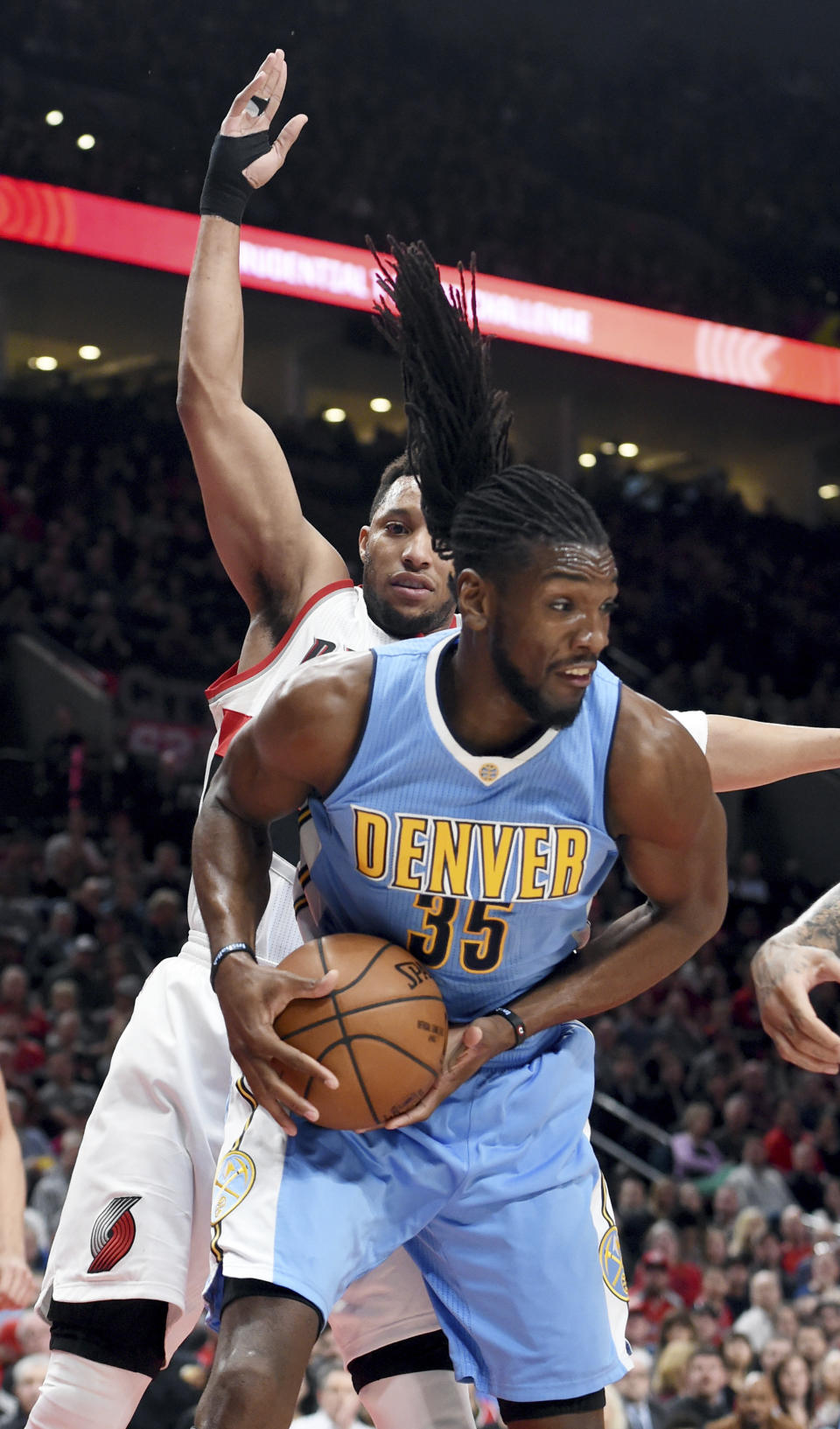 Denver Nuggets forward Kenneth Faried grabs a rebound in front of Portland Trail Blazers guard Evan Turner during the first half of an NBA basketball game in Portland, Ore., Tuesday, March 28, 2017. (AP Photo/Steve Dykes)