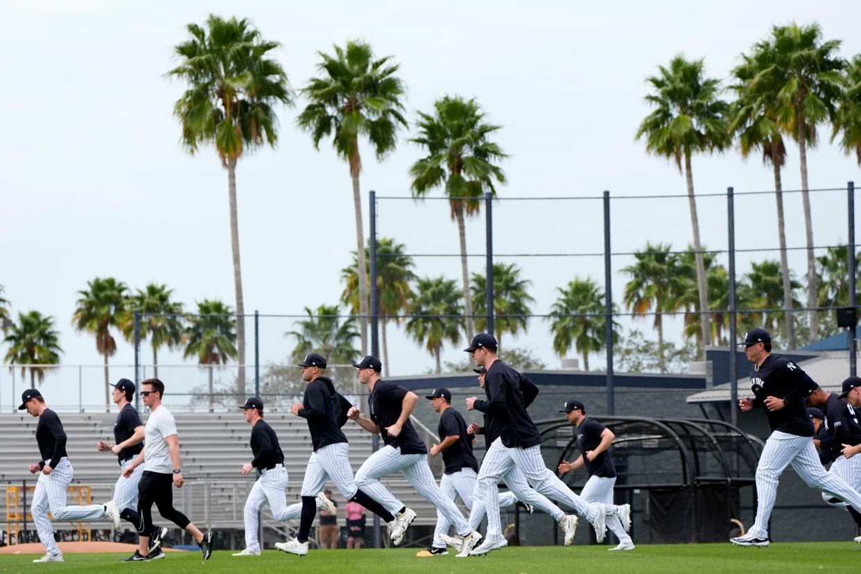 New York Yankees players run on the field during a baseball spring training workout Thursday, Feb. 15, 2024, in Tampa, Fla. (AP Photo/Charlie Neibergall)