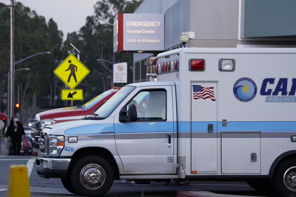 Ambulances are parked outside an emergency room entrance at Long Beach Medical Center, Tuesday, Jan. 5, 2021, in Long Beach, Calif. (AP Photo/Ashley Landis)