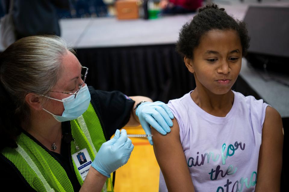 The CDC recommends people 6 months and older get the flu shot and the updated COVID-19 vaccine, if eligible. People 60 and older should get the RSV vaccine. Shiloh McCarter, 9, is seen here getting her first COVID-19 does in November 2021.