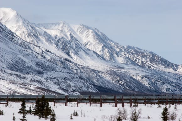 Oil Pipeline near snow covered mountain.