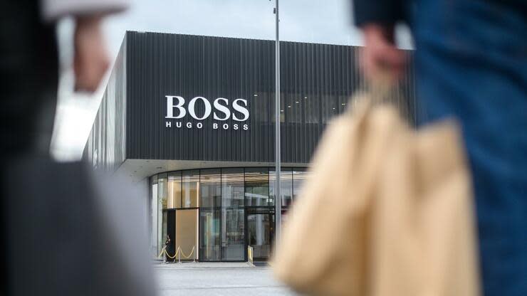 Besucher stehen vor dem neuen Flagship-Outlet von Hugo Boss in der Outlet-City in Metzingen. Foto: dpa