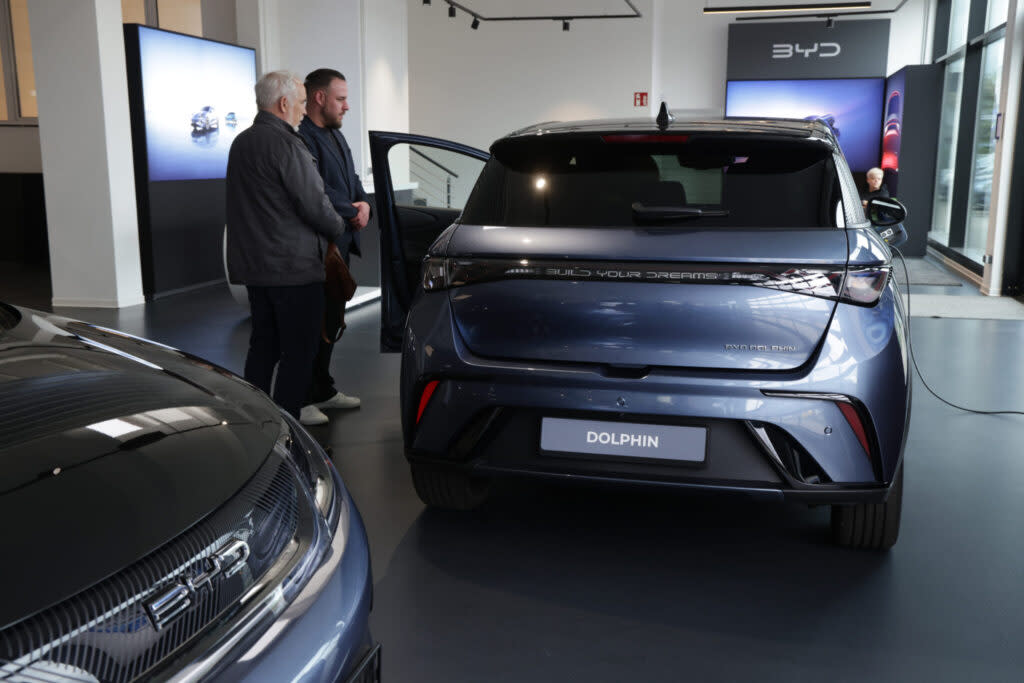 A sales representative shows prospective customers a BYD Dolphin electric car at a BYD dealership on April 05, 2024 in Berlin, Germany. BYD, which stands for Build Your Dreams, is a Chinese manufacturer that went from making solar panels to electric cars. (Sean Gallup/Getty Images)