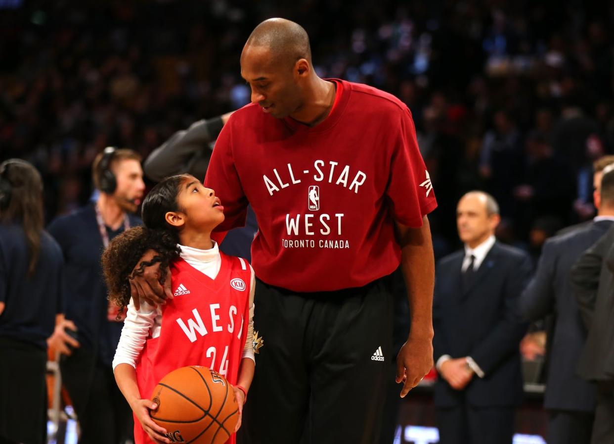 <span class="caption">Gigi Bryant, looking up to her dad on the court in 2016</span> <span class="attribution"><a class="link " href="https://www.gettyimages.com/detail/news-photo/kobe-bryant-of-the-los-angeles-lakers-and-the-western-news-photo/510291022" rel="nofollow noopener" target="_blank" data-ylk="slk:Elsa/Getty Images;elm:context_link;itc:0;sec:content-canvas">Elsa/Getty Images</a></span>