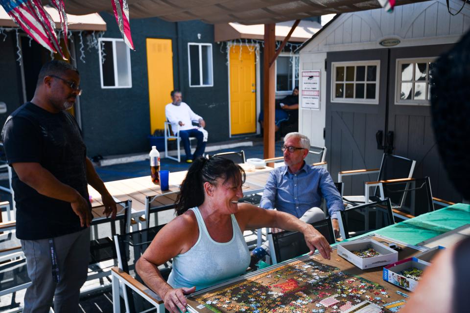 Members of the motel community work on a puzzle and converse inside the Reno Motel in Mid-City, Los Angeles on August 5, 2019.