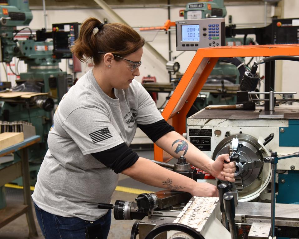 Inside machinist Stephanie Lucas prepares a training piece on a metal lathe in the Machine Shop Learning Center Feb. 13, 2020, at Portsmouth Naval Shipyard.
