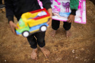 Syrian children hold donated toys in a refugee camp for displaced people supported by the Turkish Red Crescent in Sarmada district, north of Idlib city, Syria, Thursday, Nov. 25, 2021. (AP Photo/Francisco Seco)