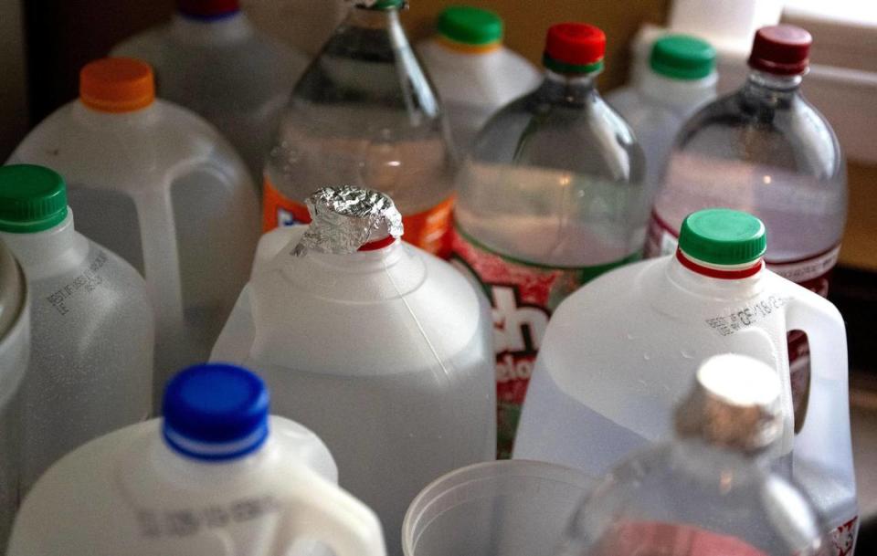 Milk jugs and pop bottles take up an entire section of Jessica Martinez’s kitchen counter at her home on Friday, May 26, 2023, in Kansas City. Due to an outstanding balance left by a previous tenant, KC Water shut off water to Martinez’s home in April. Since then, the family has had to get creative for their water needs including transporting trash cans full of water by car to their home.