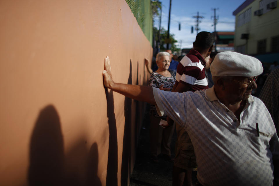 Voters wait in line to cast their ballots outside a polling station during elections in San Juan, Puerto Rico, Tuesday, Nov. 6, 2012. Puerto Ricans are electing a governor as the U.S. island territory does not get a vote in the U.S. presidential election. But they are also casting ballots in a referendum that asks voters if they want to change the relationship to the United States. A second question gives voters three alternatives: become the 51st U.S. state, independence, or sovereign free association, a designation that would give more autonomy. (AP Photo/Ricardo Arduengo)