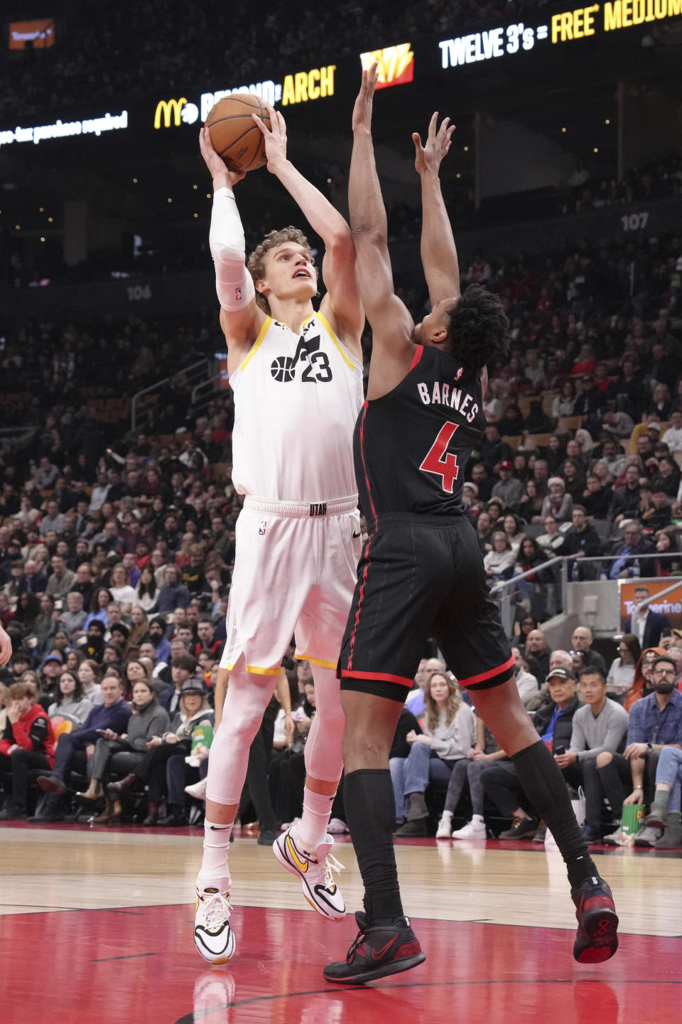 Utah Jazz forward Lauri Markkanen (23) looks to shoot over Toronto Raptors forward Scottie Barnes (4) during first-half NBA basketball game action in Toronto, Saturday, Dec. 23, 2023. (Chris Young/The Canadian Press via AP)