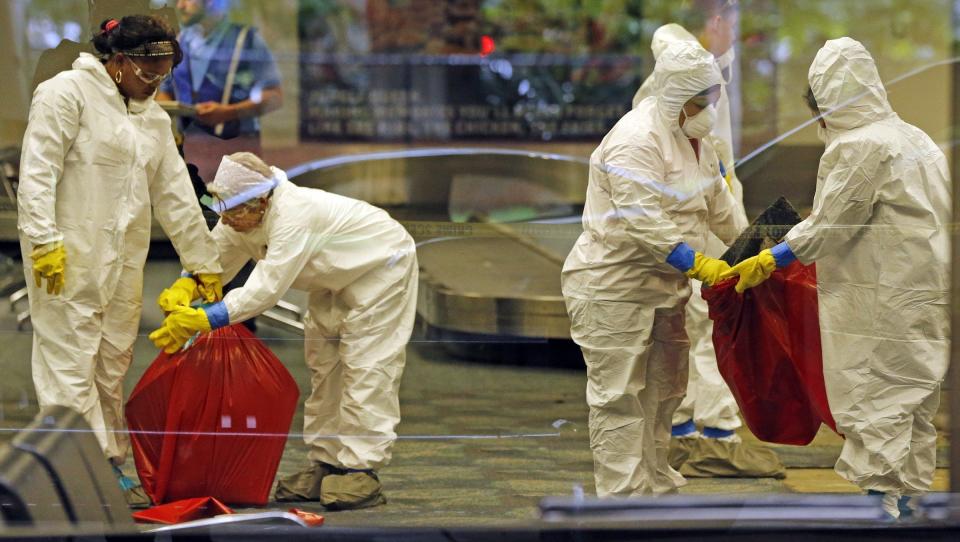 A hazmat crew cleans up baggage claim Terminal Two on Saturday, Jan. 7, 2017 at Fort Lauderdale-Hollywood International Airport Terminal the day after multiple people were shot on Friday.(Al Diaz/Miami Herald via AP)